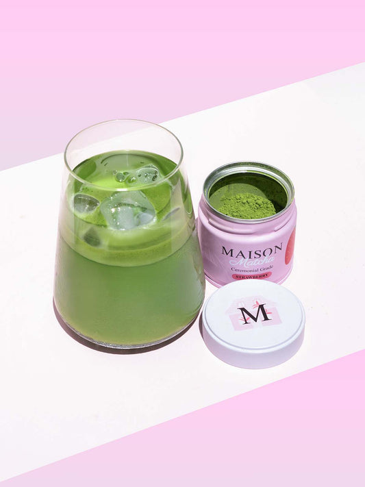 Iced matcha latte next to Maison Matcha strawberry can open with fresh matcha powder, best strawberry matcha powder