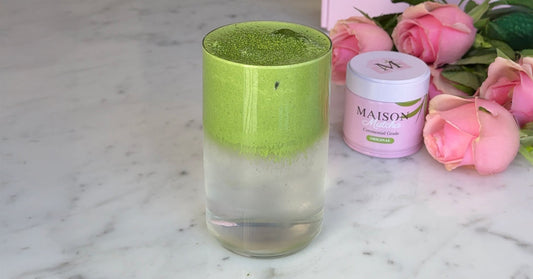Coconut cloud matcha drink next to a can of Maison Matcha Ceremonial Original and fresh flowers