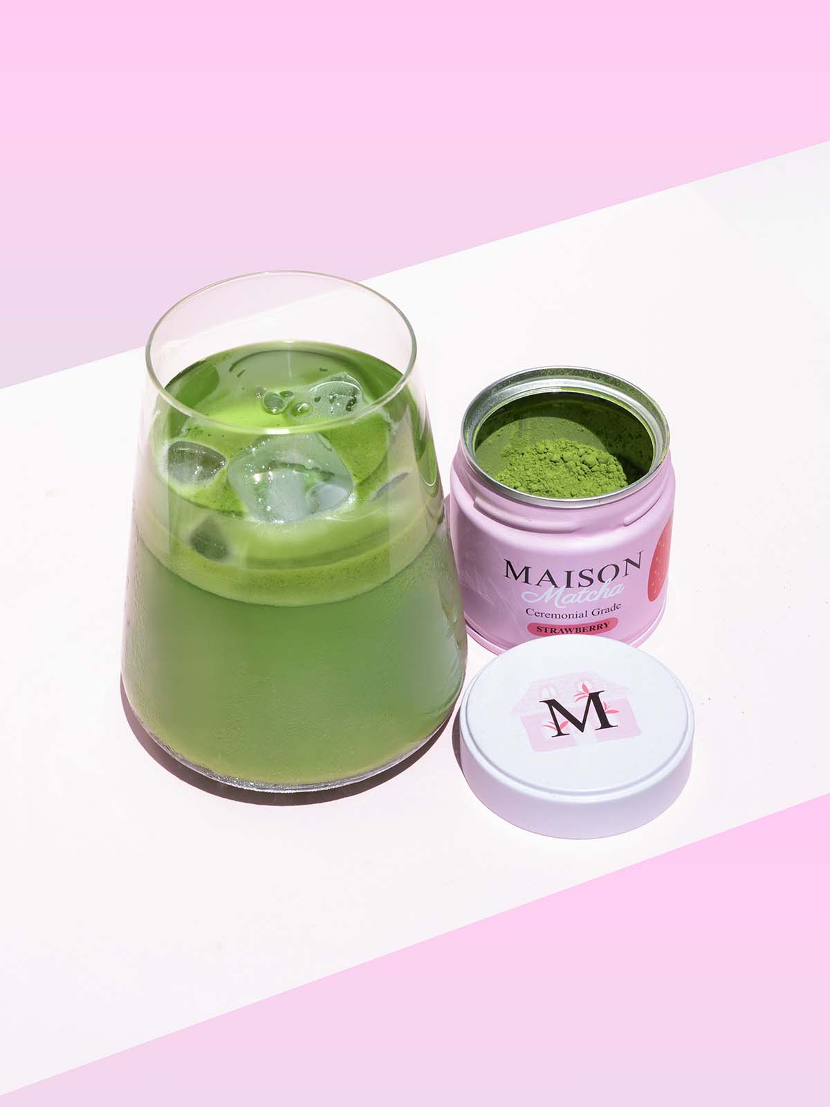 Iced matcha latte next to Maison Matcha strawberry can open with fresh matcha powder, best strawberry matcha powder