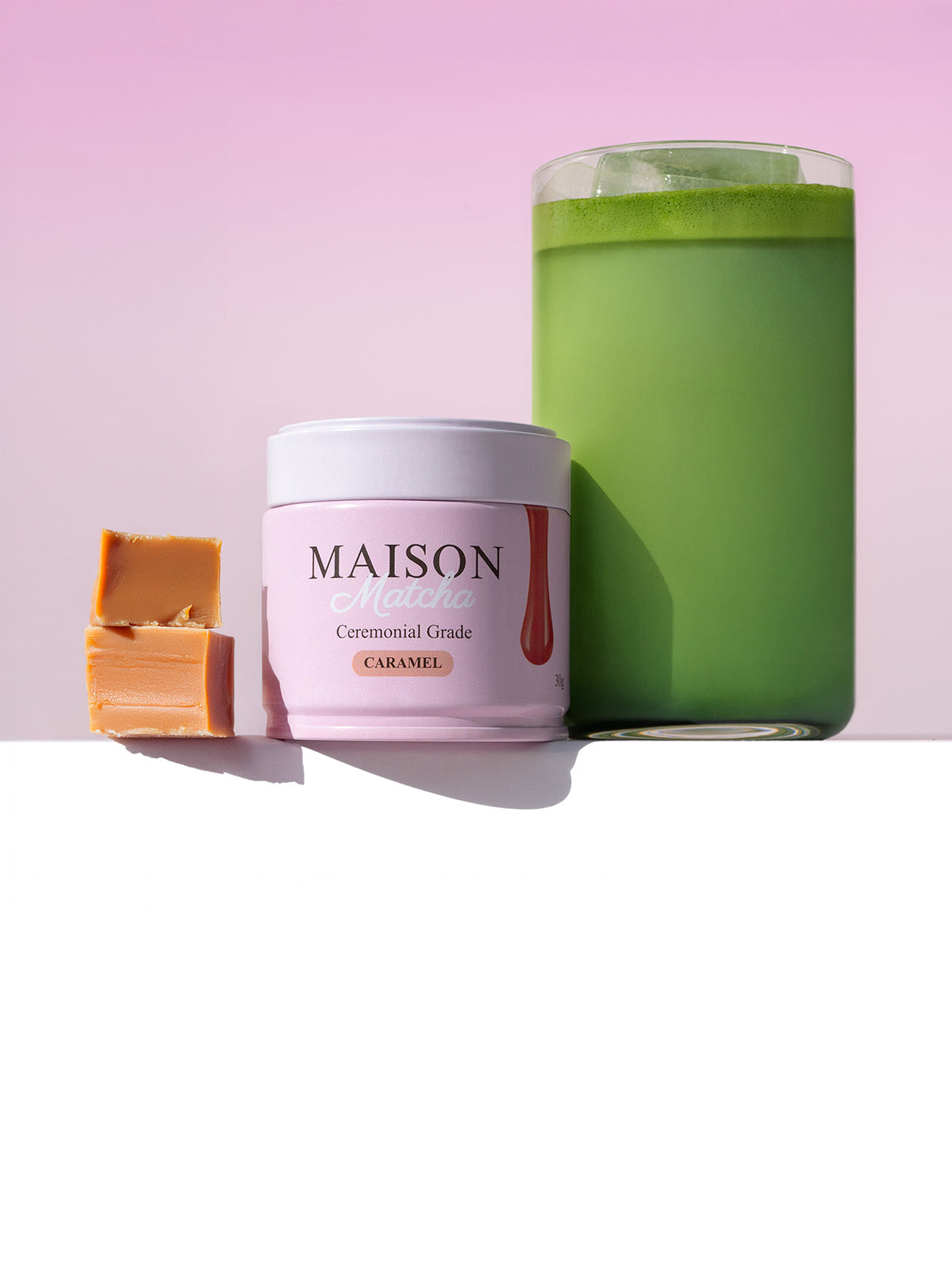 Maison Matcha Ceremonial Caramel Matcha can next to iced matcha latte and two caramel bites