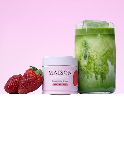 Maison Matcha's strawberry matcha can next to iced matcha latte and fresh strawberries