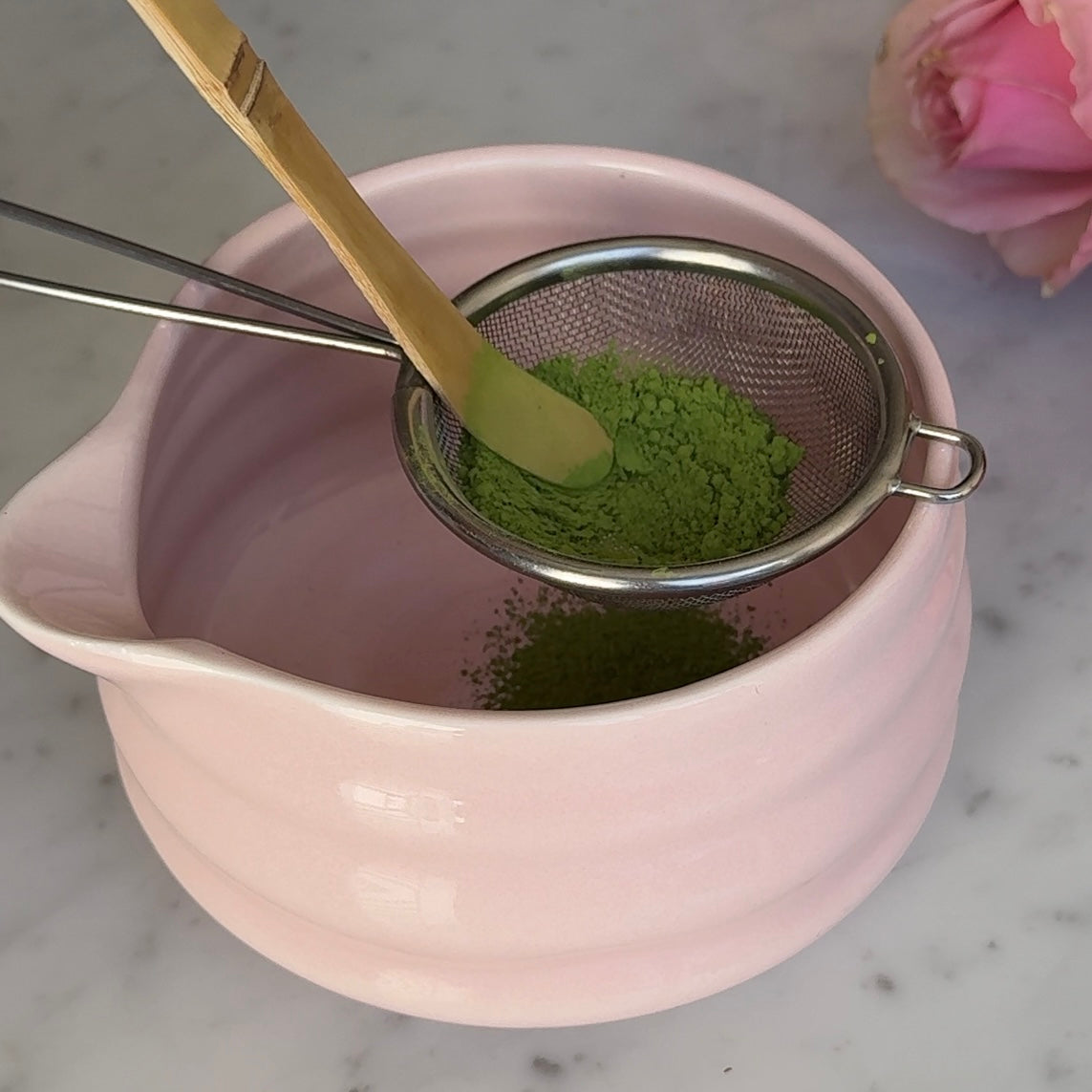 Maison Matcha's matcha powder being sifted in a pink matcha bowl
