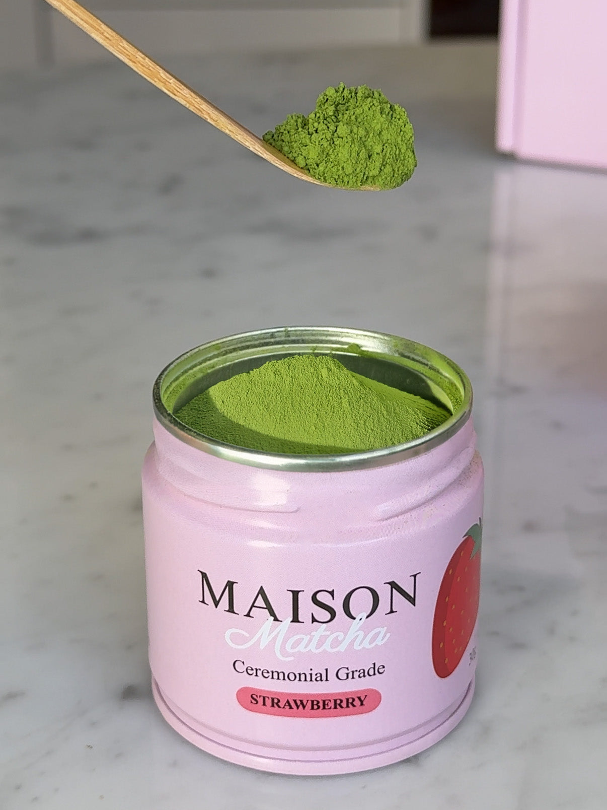 Maison Matcha's strawberry matcha powder being scooped out of pink can
