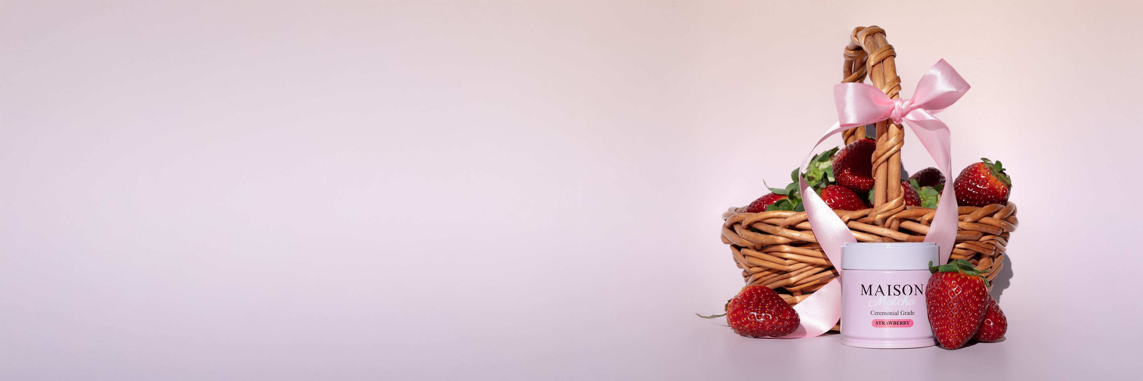 Ceremonial Strawberry Matcha can displayed in basket with strawberries and decorative pink ribbon