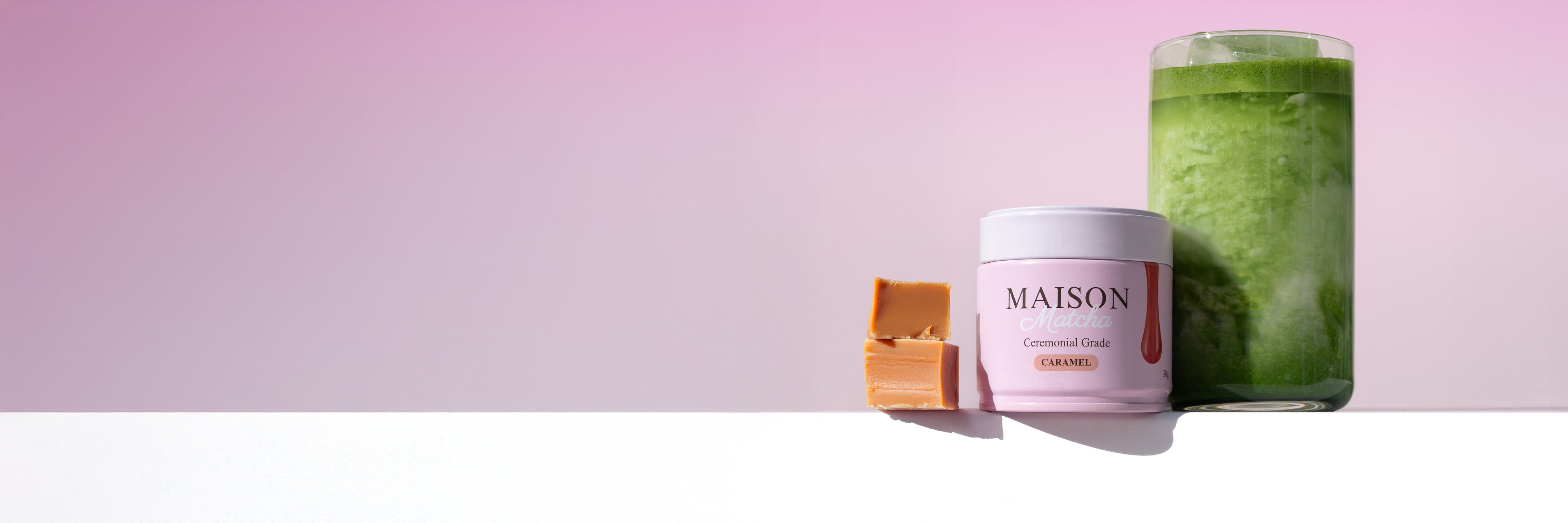 Maison Matcha Ceremonial Caramel Matcha can next to iced matcha latte and two caramel bites