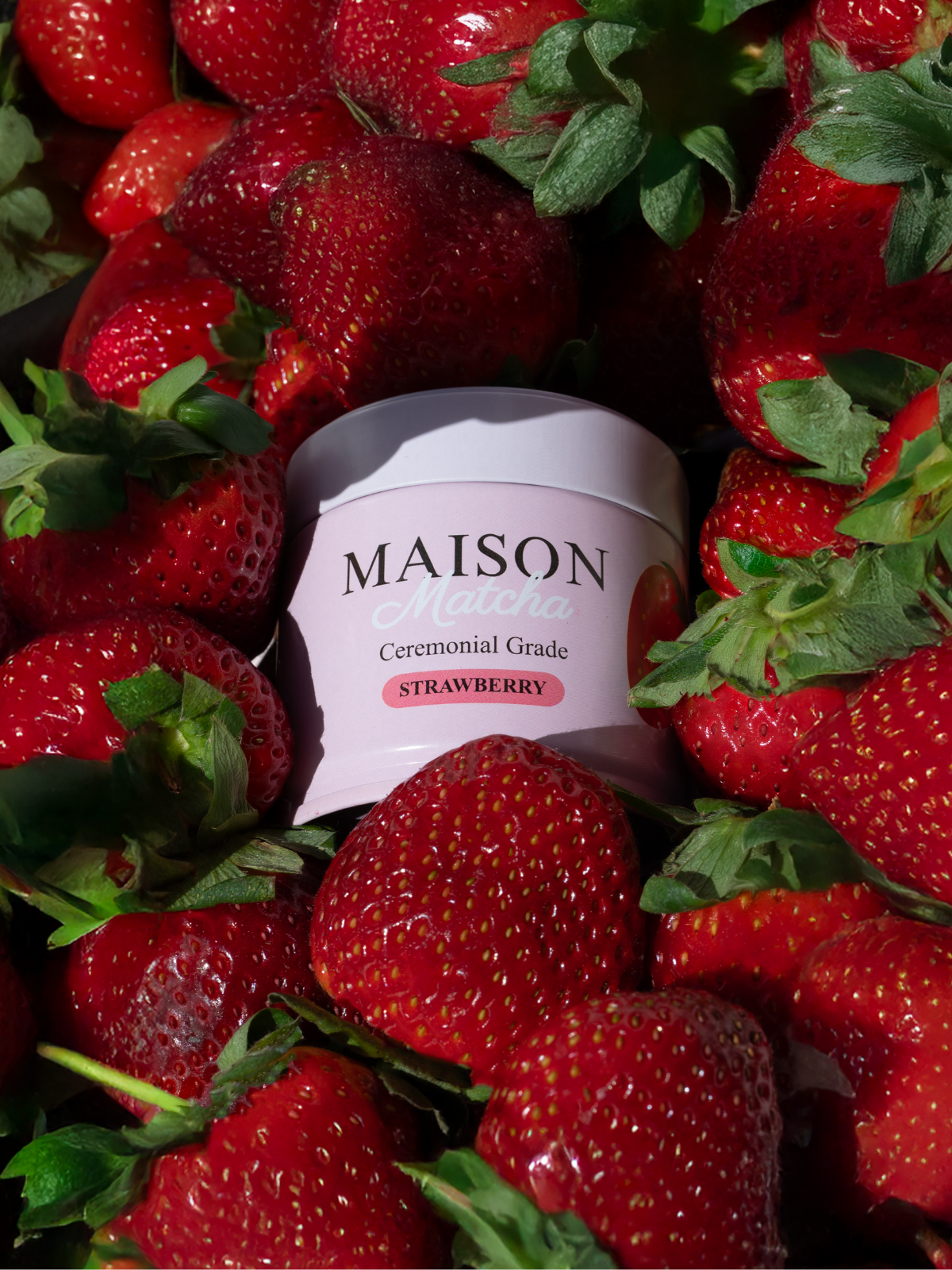 Maison Matcha Ceremonial Strawberry Matcha 30g can surrounded by fresh strawberries