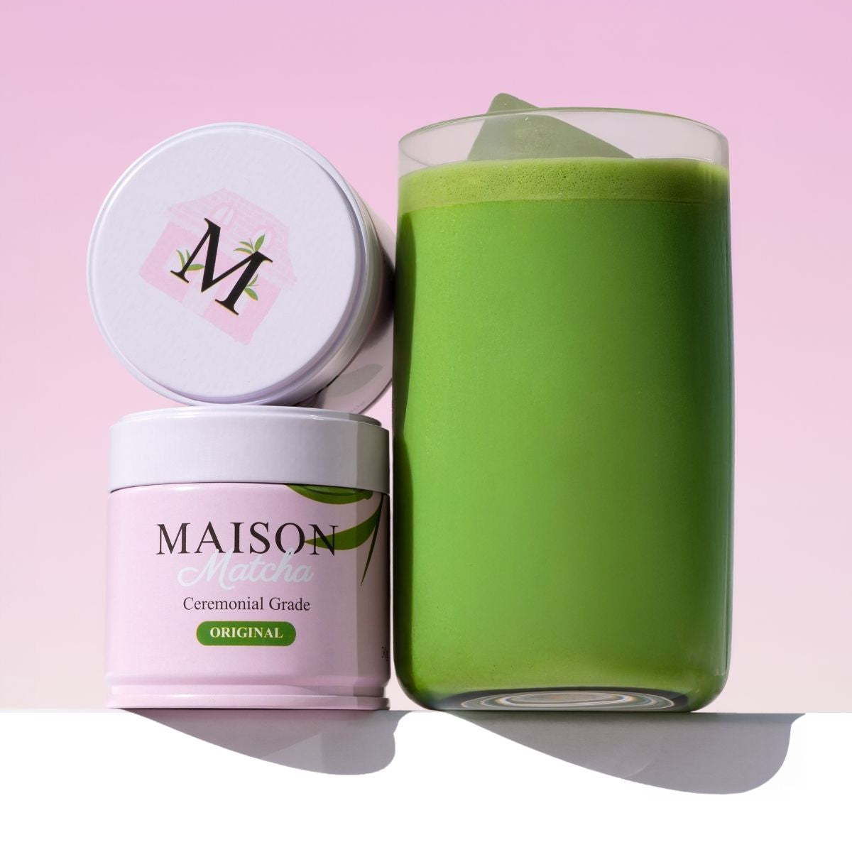 Ceremonial matcha powder cans with freshly prepared green iced matcha